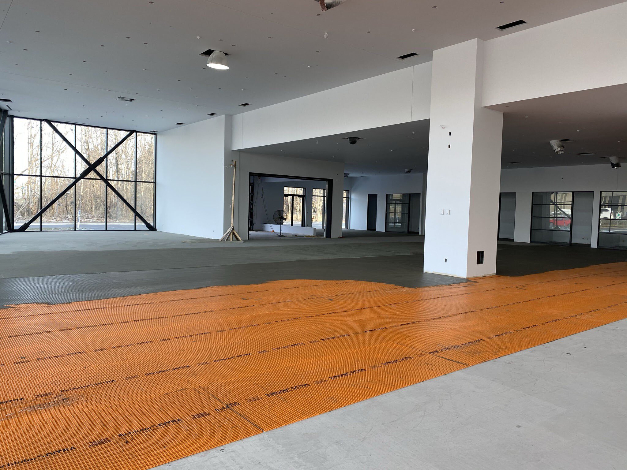 La membrane DITRA de Schluter Systems est installée et cimentée dans la salle d'exposition Lamborghini Montréal.