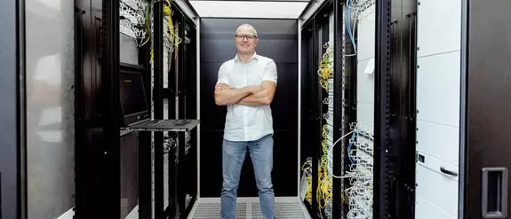 IT-Mitarbeiter steht im Serverraum