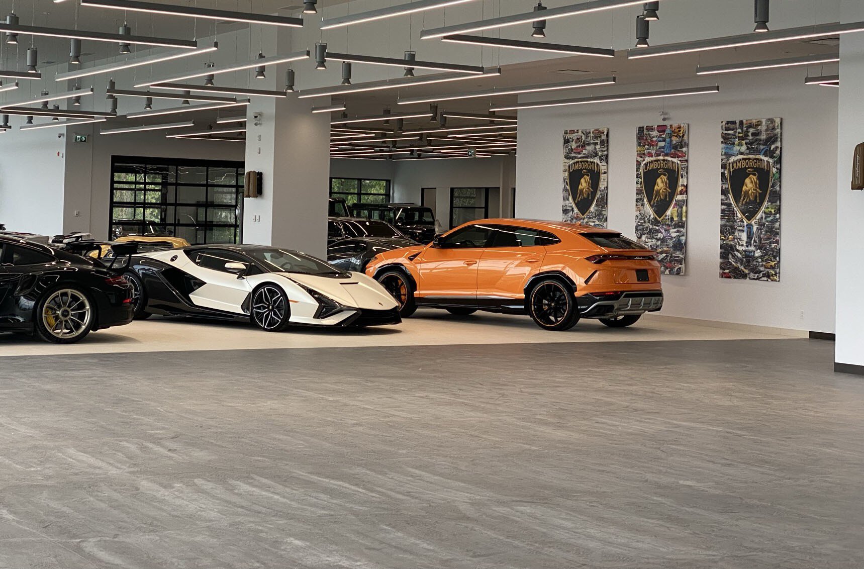 Lamborghinis noires, blanches et oranges exposées dans la salle d'exposition de Montréal.