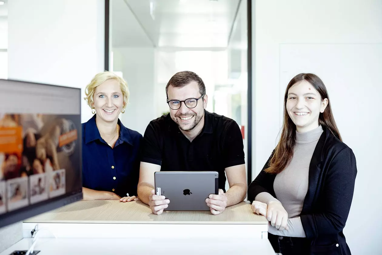 U konferenčn&iacute;ho stolu stoj&iacute; tři zaměstnanci firmy Schl&uuml;ter-Systems, prostředn&iacute; z nich drž&iacute; v rukou tablet.