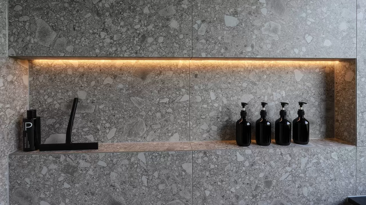 Vista detallada de la pared de la ducha a nivel de suelo con hornacina iluminada