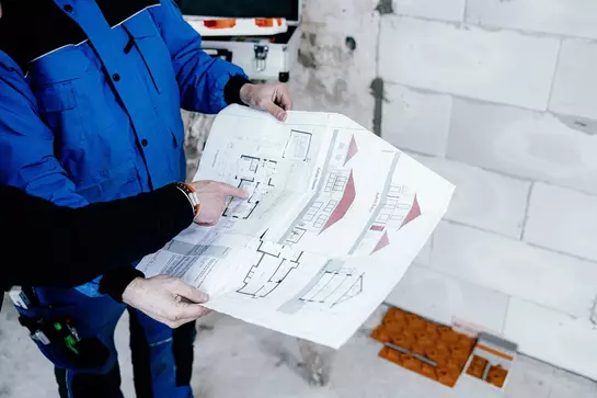 Két építész megnézi egy ingatlan alaprajzát, hogy megtervezze a BEKOTEC-THERM padlófűtés beépítését