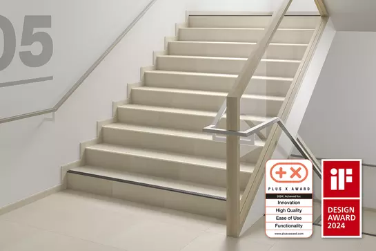 Detailed view of a stair tread with Schl&uuml;ter-TREP-V stair profile installed for anti-slip protection.