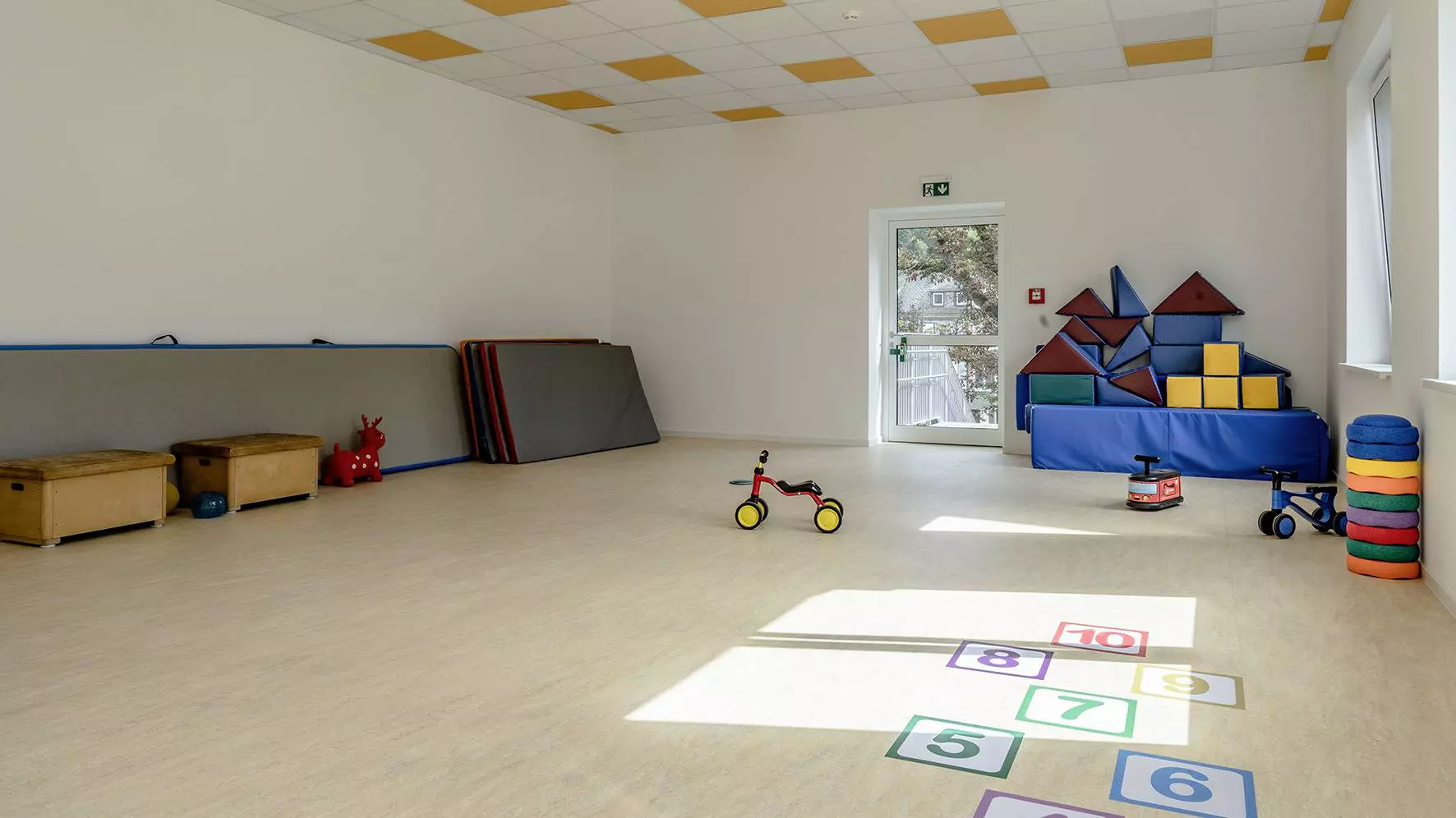 Gro&szlig;er Turnraum im Kindergarten der Marktschule mit Matten, Turnelementen und Spielen