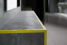 Pelda&ntilde;o con recubrimiento de baldosas grises y borde de perfil amarillo en contraste.