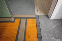 Passage de porte &eacute;tanch&eacute;ifi&eacute; avec KERDI-CID entre une salle de bains carrel&eacute;e et une pi&egrave;ce &agrave; vivre adjacente avec parquet
