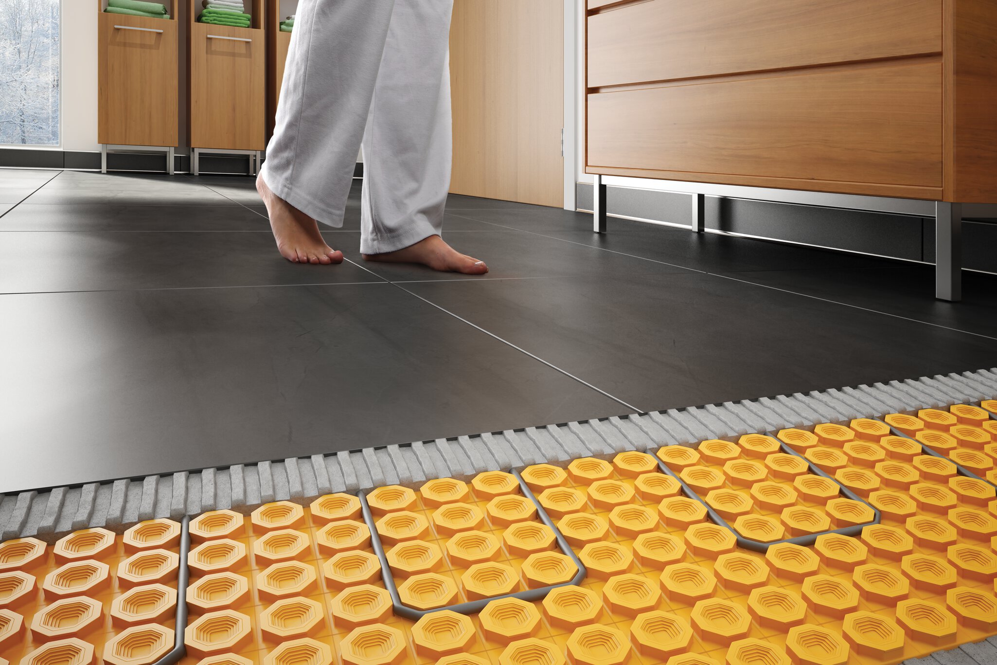 Personne pieds nus sur un plancher de céramique chauffants avec la membrane Ditra-Heat