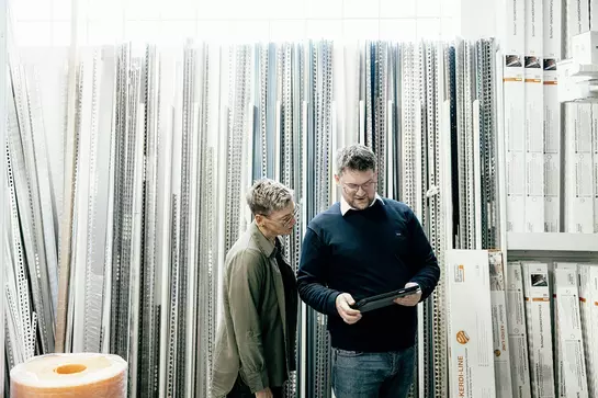 Een buitendienstmedewerker van Schl&uuml;ter-Systems adviseert een klant voor een schap met Schl&uuml;ter-producten.
