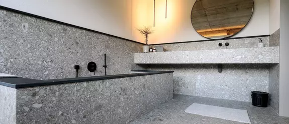 Une salle de bains avec un carrelage de couleur gris pierre et plusieurs produits, tels que Schl&uuml;ter-KERDI-LINE et Schl&uuml;ter-QUADEC.