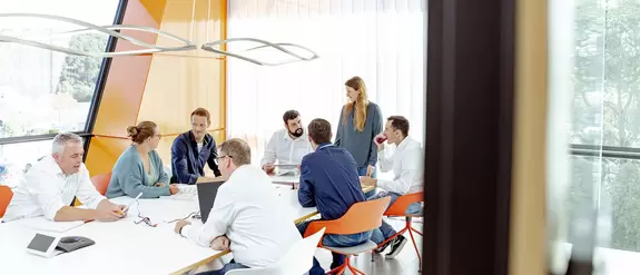 Meetingsituation mit mehreren Mitarbeiterinnen und Mitarbeitern