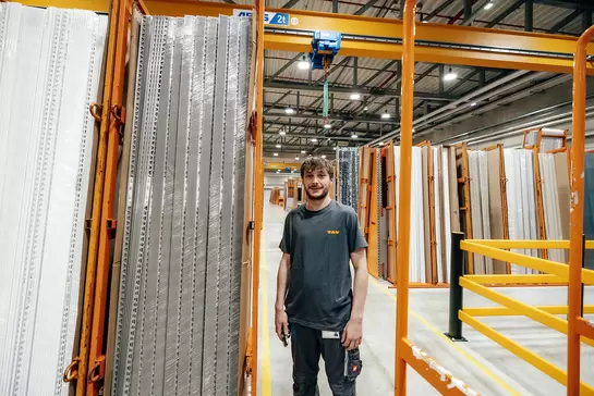 Logistikmitarbeiter steht im Logistikzentrum vor Lagerregalen