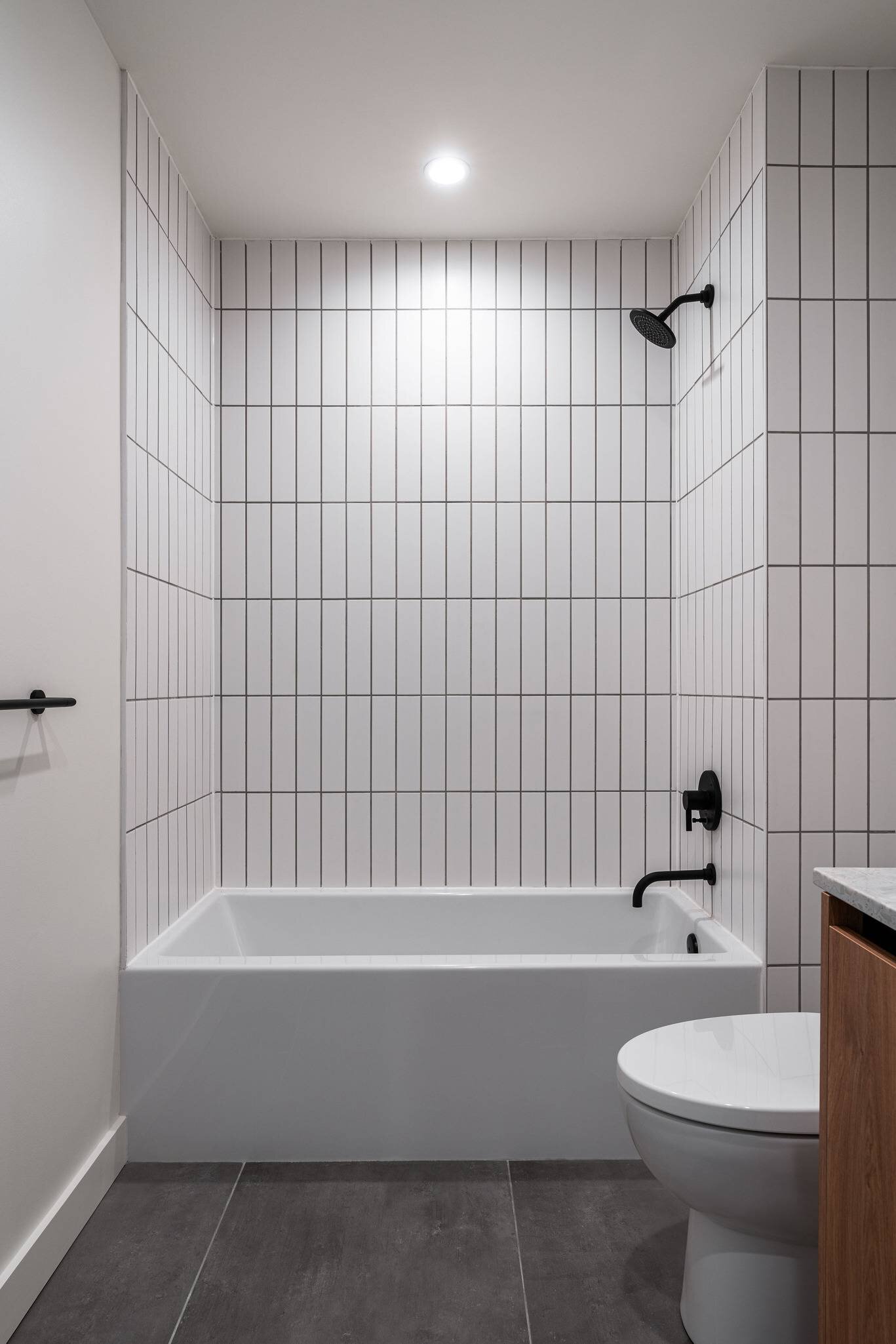 Une baignoire-douche avec murs carrelés dans le projet de logements multifamiliaux Vesper à Austin, Texas.