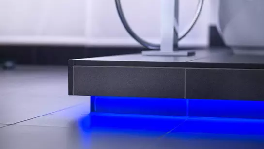 Blau beleuchteter Sockel vor einer Badewanne