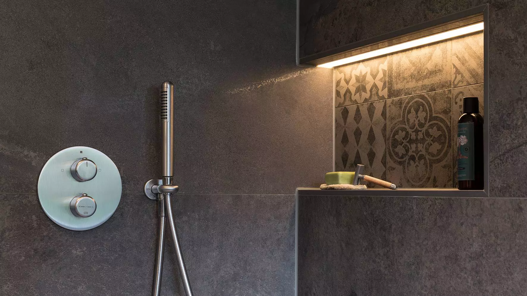 Foto van een verlichte nis voor douchegel en shampoo in de douche.