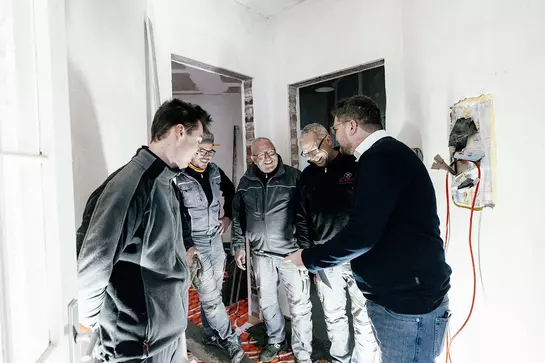 Schl&uuml;ter-Systems-Handwerker und Schl&uuml;ter-Systems-H&auml;ndler schauen auf eine Arbeitsmappe.