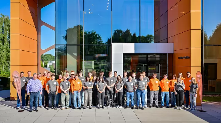 Gruppenfoto mit Gesch&auml;ftsf&uuml;hrer Udo Schl&uuml;ter, Ausbildern und zahlreichen Schl&uuml;ter-Azubis vor dem Schulungszentrum, der Schl&uuml;ter-WorkBox