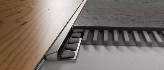 Detailaanzicht van een constructie met Schl&uuml;ter-RENO-U tussen twee vloerbekledingen.