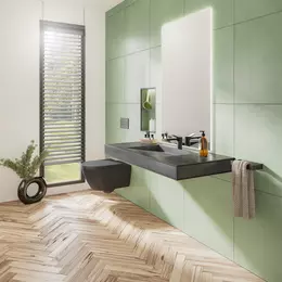 Lavabo suspendu et accessible en chaise roulante dans une salle de bains lumineuse, carrel&eacute;e de vert clair