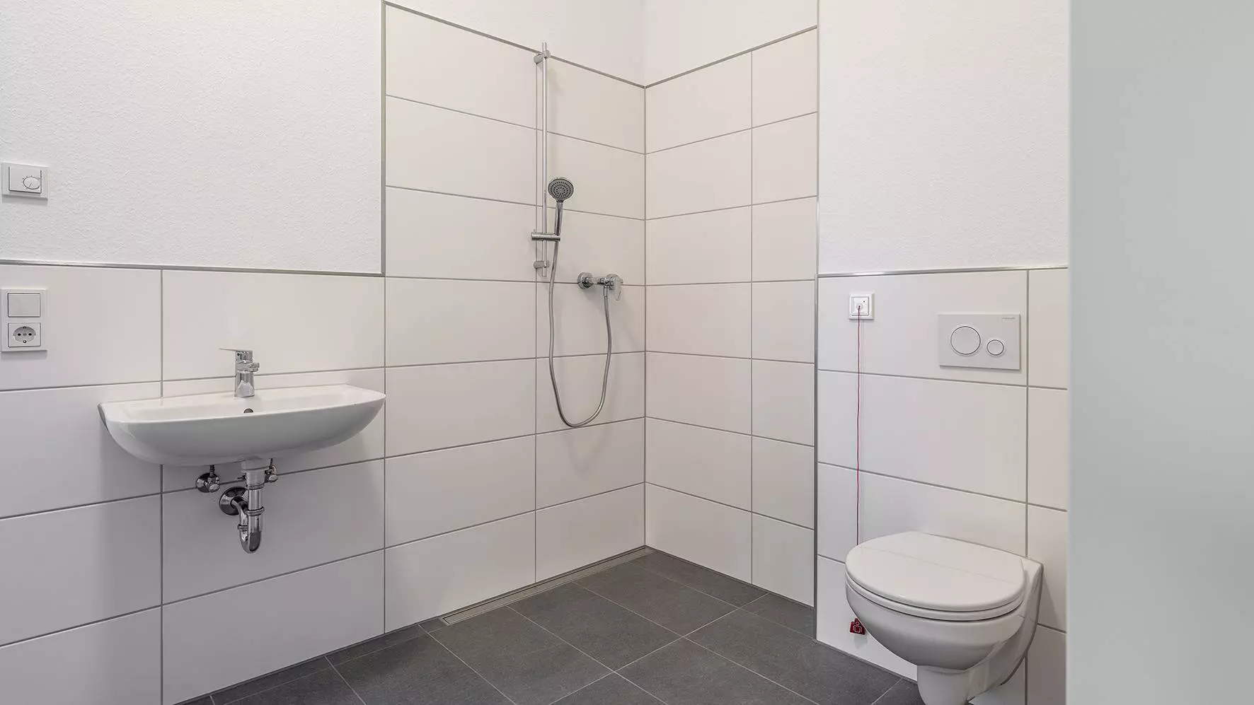 Helles, barrierefreies Bad mit WC, Duschbereich und Waschbecken