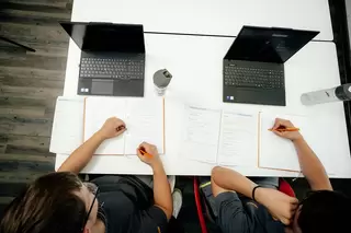 Zwei Azubis lernen mit ihren Laptops vor sich
