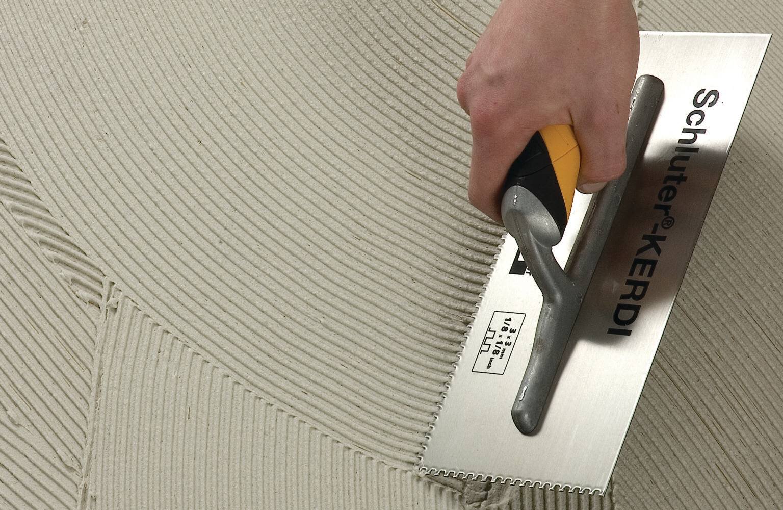 Application de ciment-colle avec la truelle Schluter