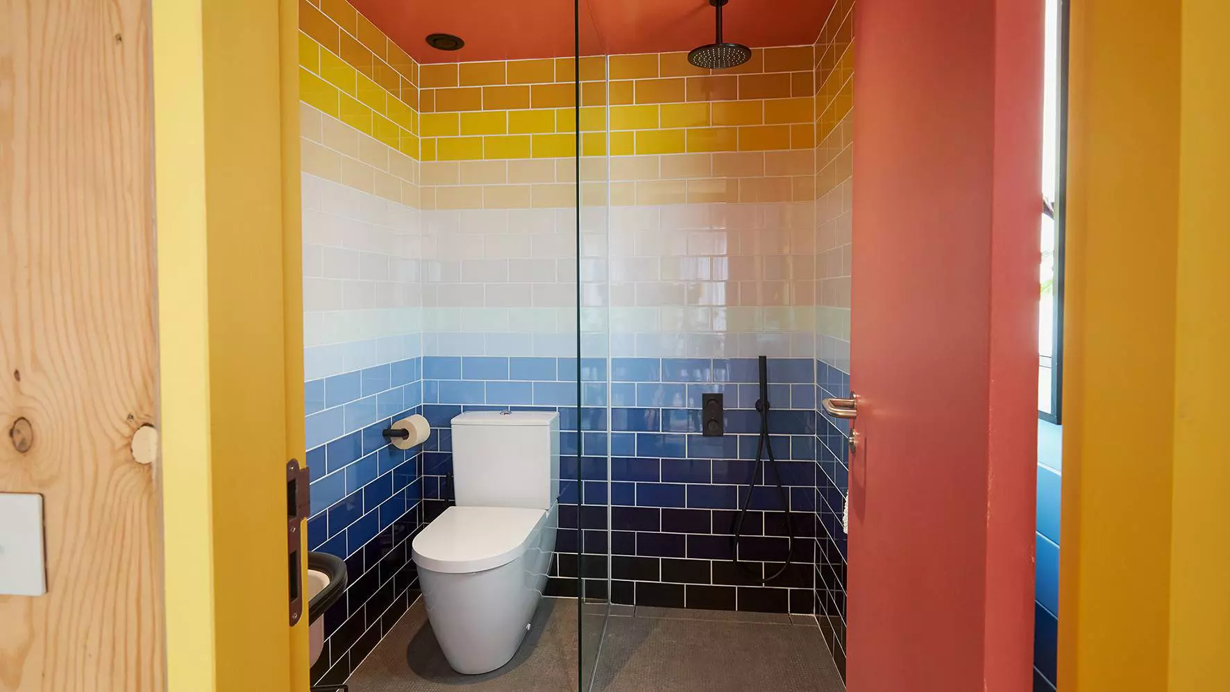 Foto de un colorido cuarto de ba&ntilde;o con ducha e inodoro
