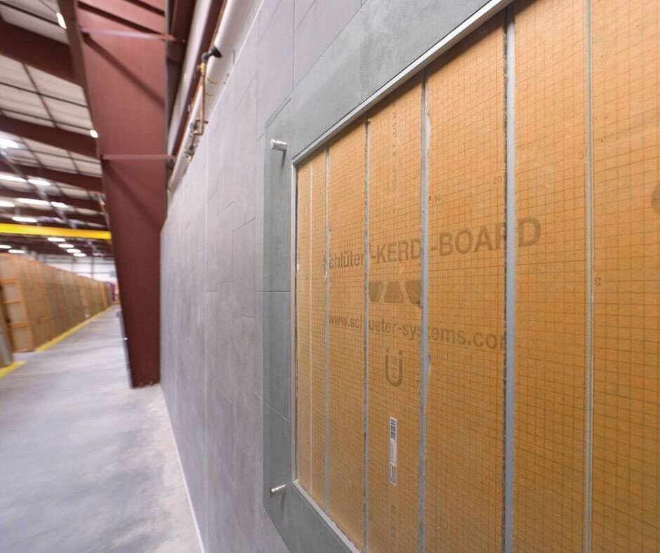 Coupe murale dans l’entrepôt de Plattsburgh montrant le KERDI-BOARD sous les carreaux.