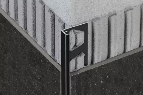 Vue d&eacute;taill&eacute;e du profil&eacute; Schl&uuml;ter-SCHIENE-AC en finition MGS pour plinthes et finition de rev&ecirc;tements carrel&eacute;s.