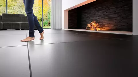 Une femme marche pieds nus sur une surface carrel&eacute;e &agrave; c&ocirc;t&eacute; d'une chemin&eacute;e