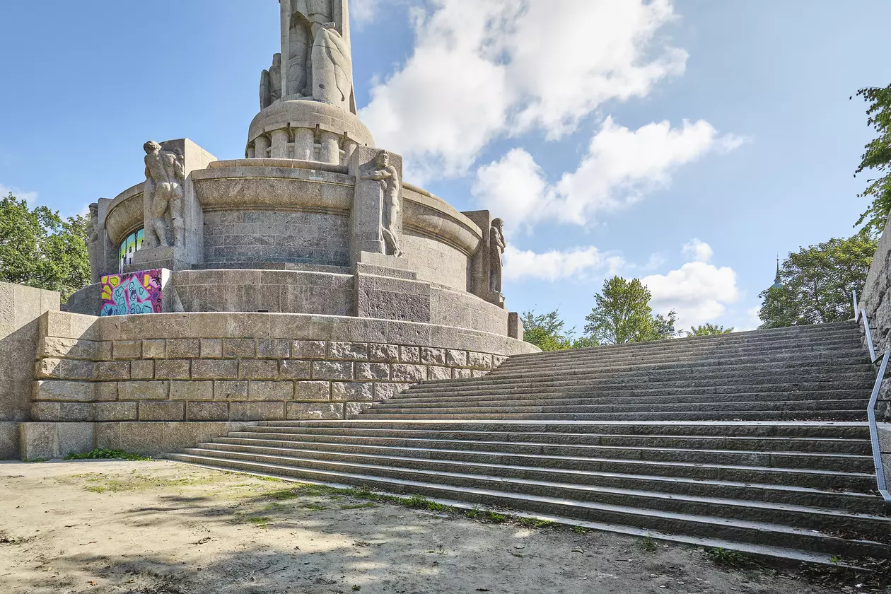 En bred trappuppg&aring;ng leder till Bismarck-monumentet p&aring; en kulle. I bakgrunden finns n&aring;gra tr&auml;dkronor och bl&aring; himmel med enstaka moln.
