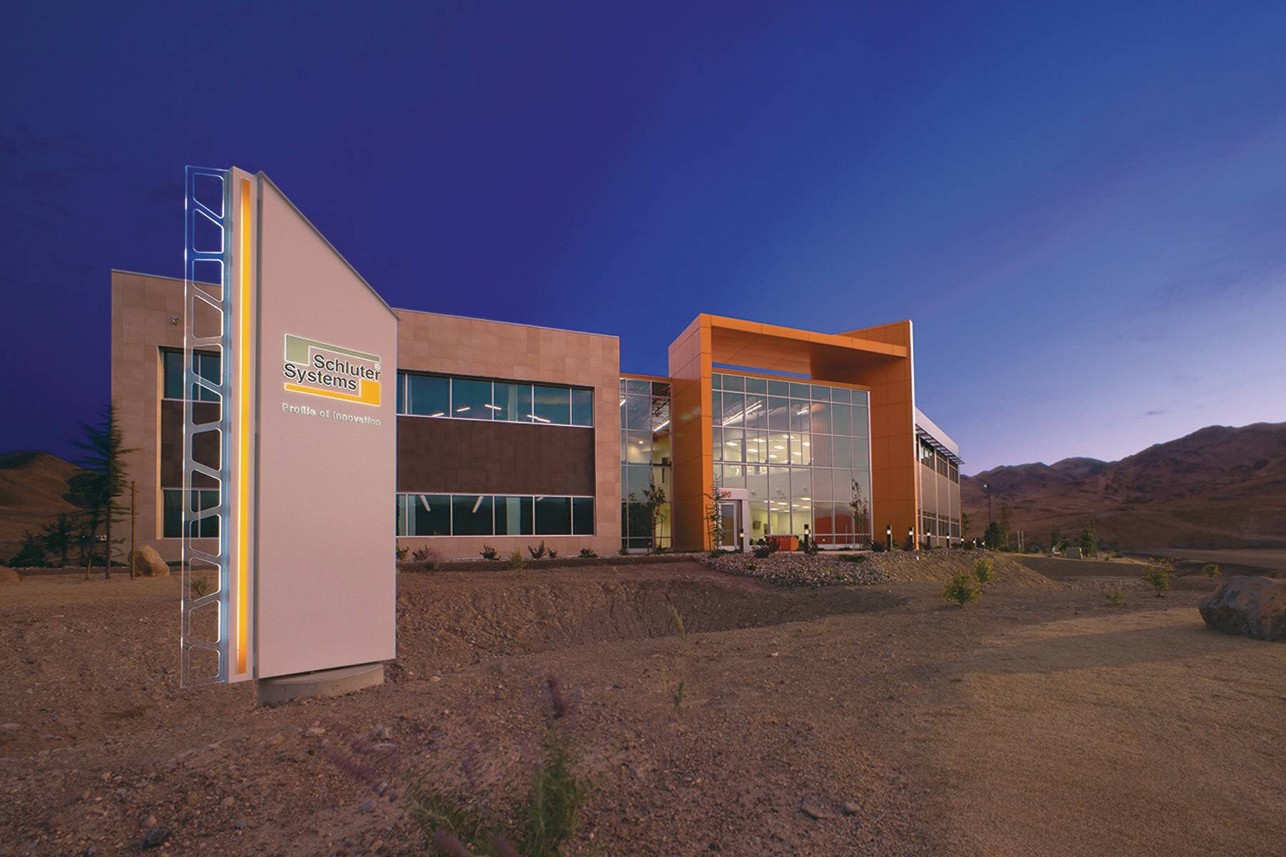 Façade du bureau Schluter à Reno au crépuscule, avec les montagnes en arrière-plan.