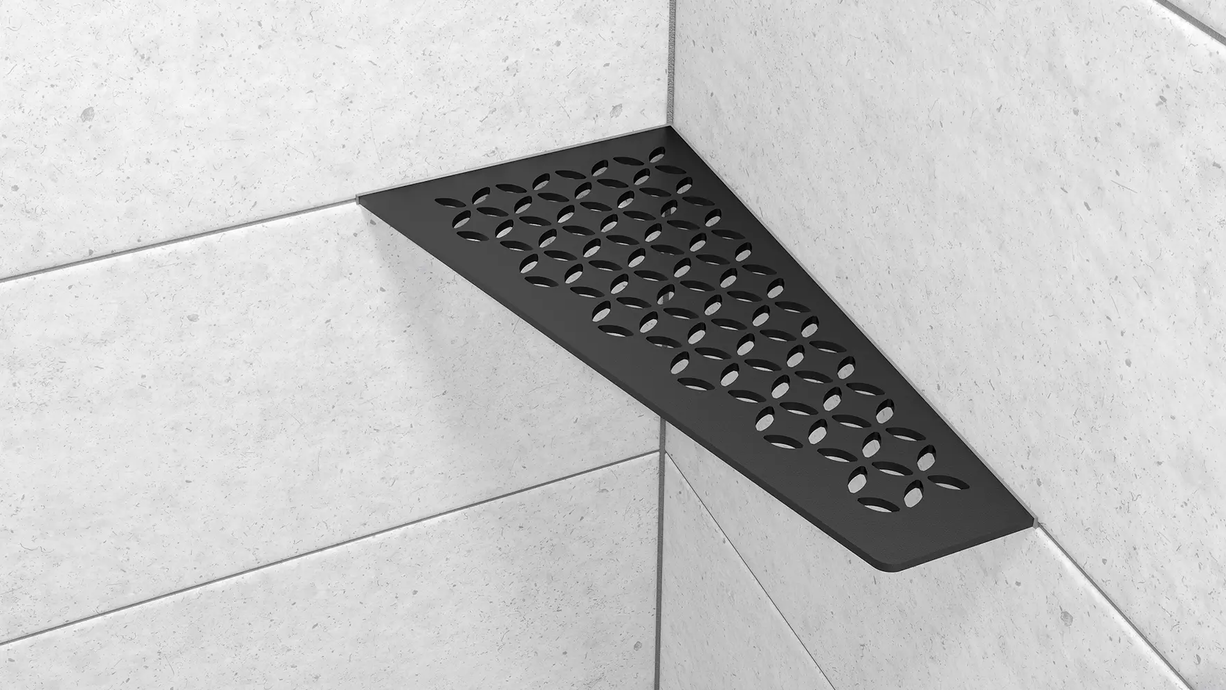 Vue d'une tablette d'angle Schl&uuml;ter-SHELF-E-S3 de forme rectangulaire avec design FLORAL et finition MGS, noir graphite mat, mise en œuvre sur un carrelage mural gris clair.