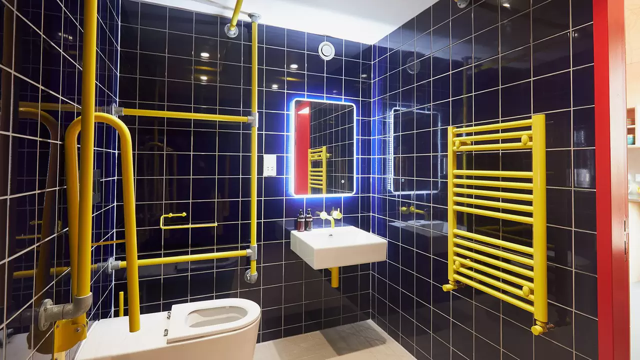 Photo of a blue tiled bathroom that is fully accessible