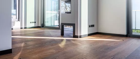 Innenraum der renovierten Villa Pomona in Ahrensburg mit Holzdielen und schwarzen DESIGNBASE-SL Fu&szlig;leisten