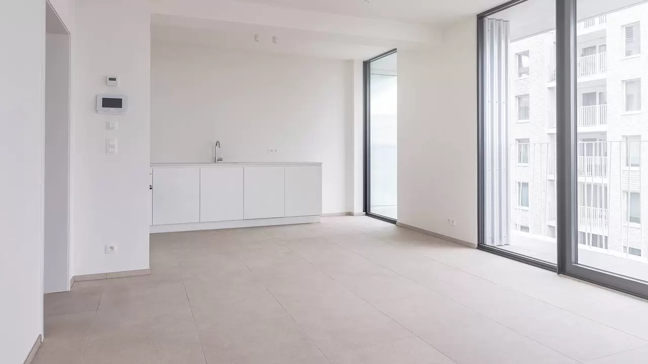 Afgewerkte, lichte woonruimte in City Dox met keukenblok, ramen tot aan de vloer en een lichte tegelvloer