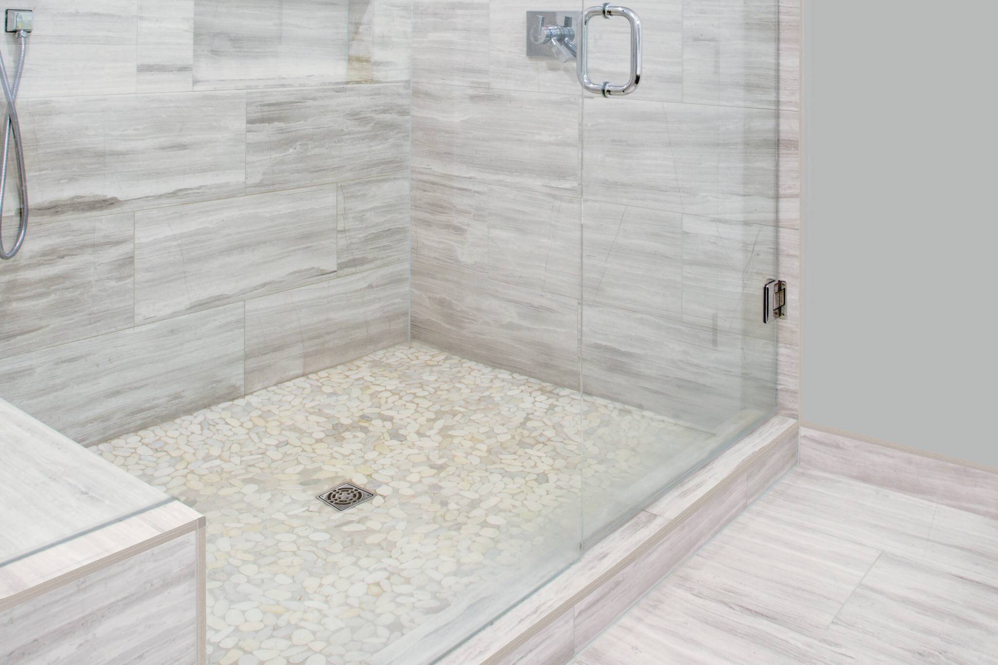 Grande douche avec porte en verre et céramique grise, drain central avec grille Classic
