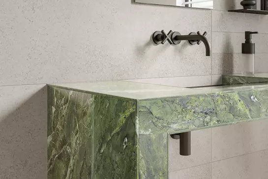 Lavabo carrel&eacute; marbr&eacute; vert avec profil&eacute;s de protection des chants assortis, imprim&eacute;s dans le design du carrelage