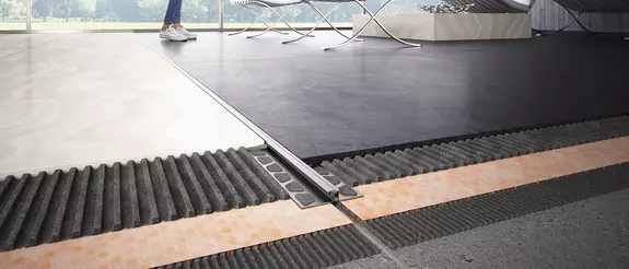 Vue d&eacute;taill&eacute;e avec Schl&uuml;ter-DILEX entre deux rev&ecirc;tements de sol.