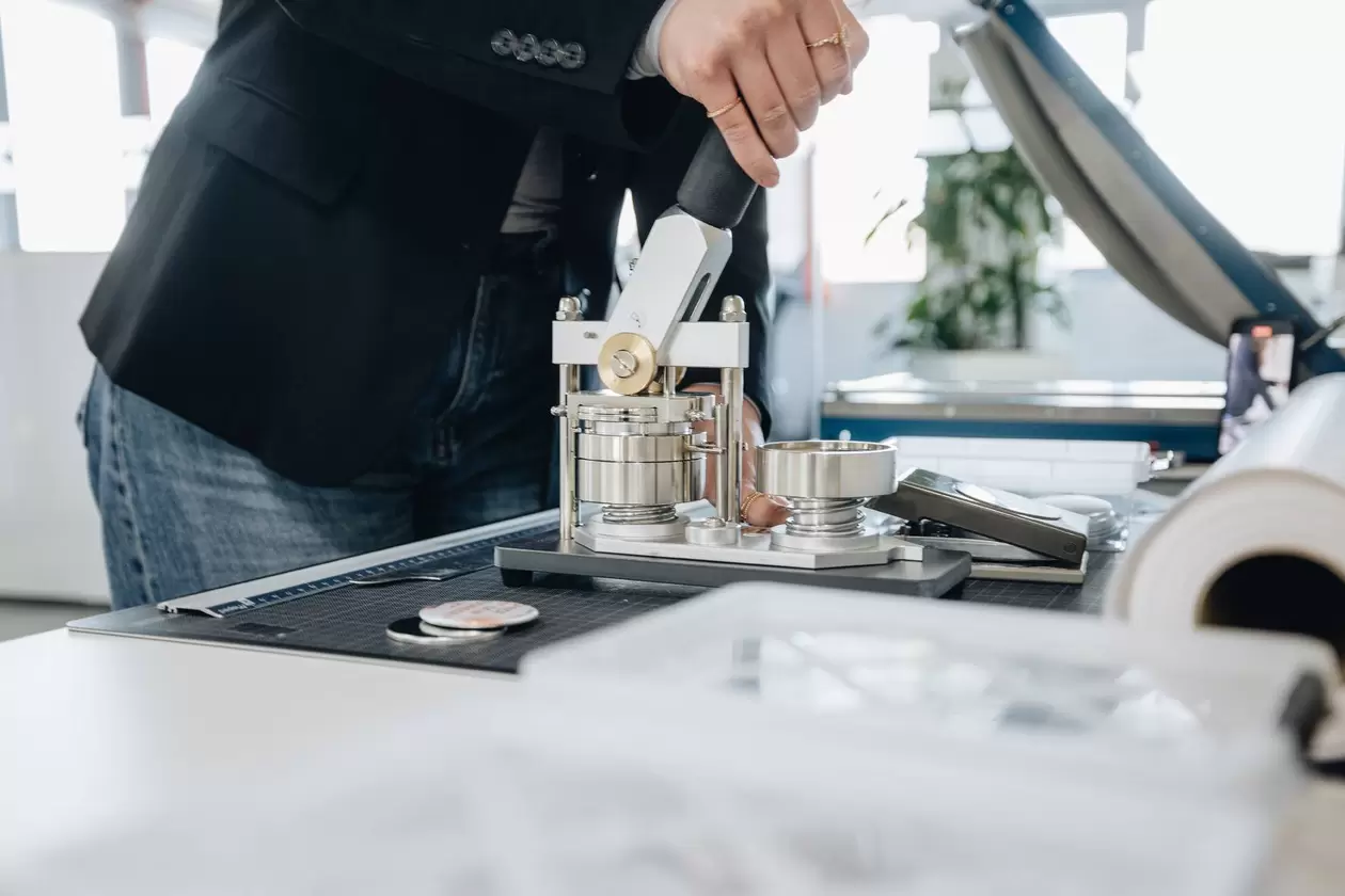 Marketing-Auszubildende bedient eine Button-Maschine