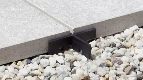 In een splitbed geplaatste terrastegels met een voegkruisje als afstandhouder