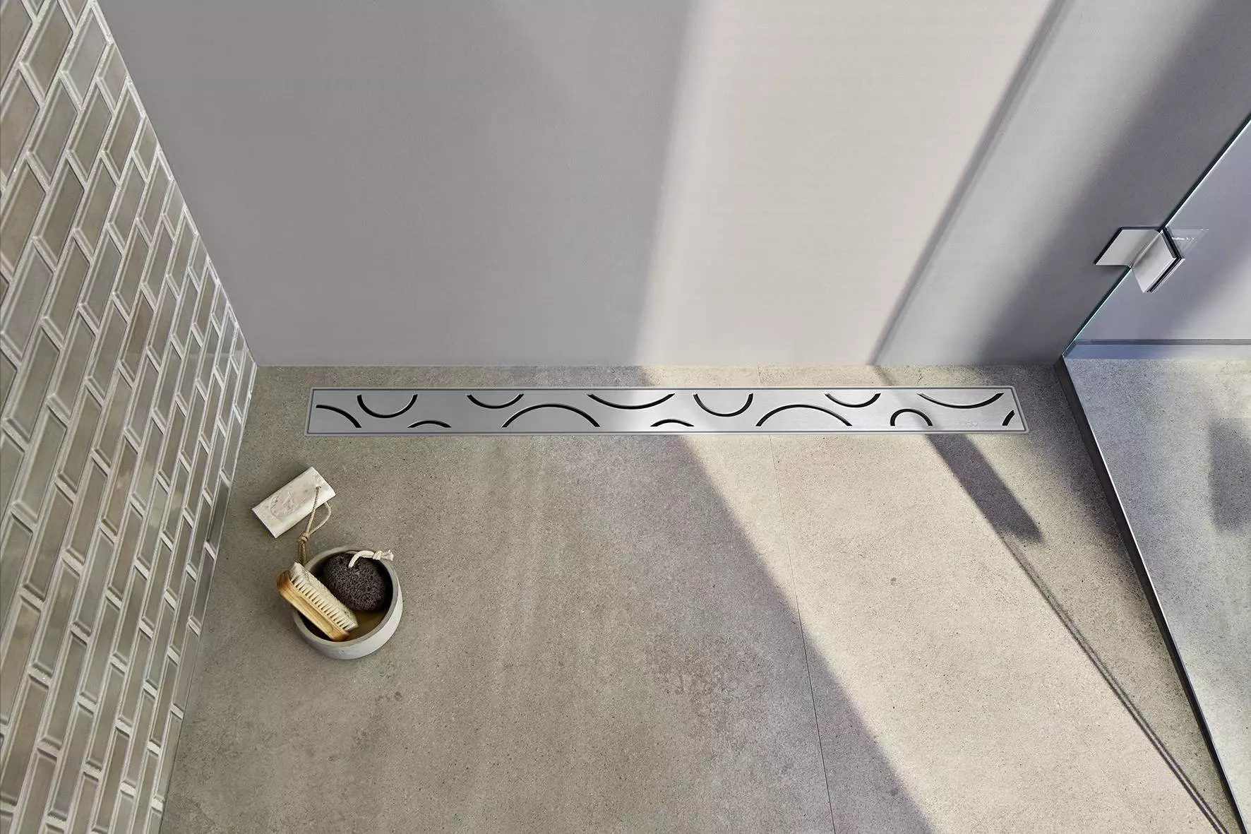 Birdseye view of patterned stainless steel wetroom shower drain