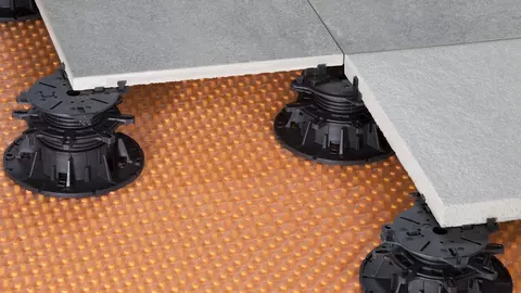 Terrastegels op tegeldragers die op een oppervlaktedrainage TROBA-PLUS-G met open weefsel staan