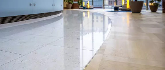 De BEKOTEC-THERM-vloerverwarming in de ronde ingangshal van de 'Frankfurter Messeturm' is voor &eacute;&eacute;n helft met royale lichte marmertegels en voor de andere helft met parket bekleed.