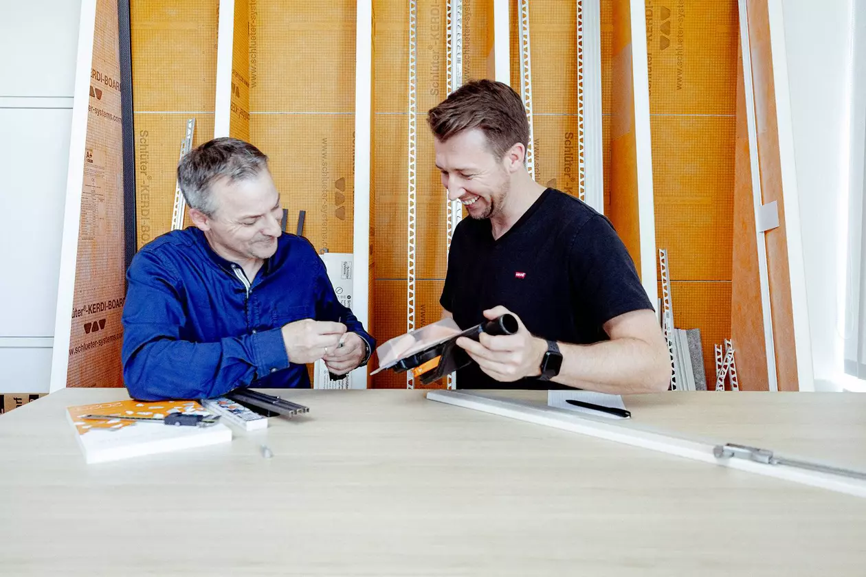 Deux coll&egrave;gues masculins &eacute;changent leurs impressions sur des produits