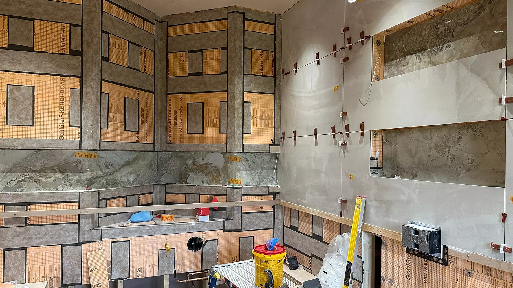 Construction site of a bathroom with backerboard substrate and niche elements on the shaped walls