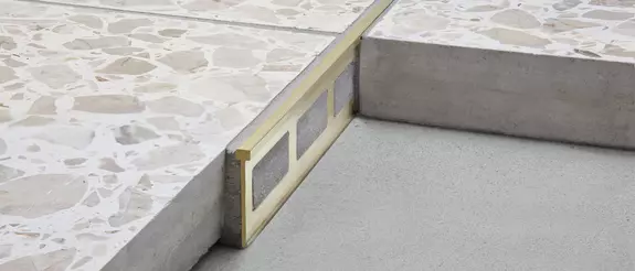 Vista detallada de una construcci&oacute;n con perfil de separaci&oacute;n Schl&uuml;ter-TERRAZZO-M entre dos recubrimientos de suelo.