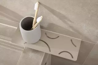 Schl&uuml;ter-SHELF polcok TRENDLINE bevonattal egy b&eacute;zs sz&iacute;nű f&uuml;rdőszob&aacute;ban.