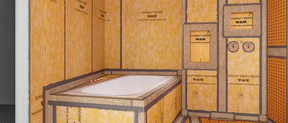 Ein fertig abgedichtetes Badezimmer im Rohbauzustand mit verklebten Entkopplungsmatten und Verlegeuntergr&uuml;nden