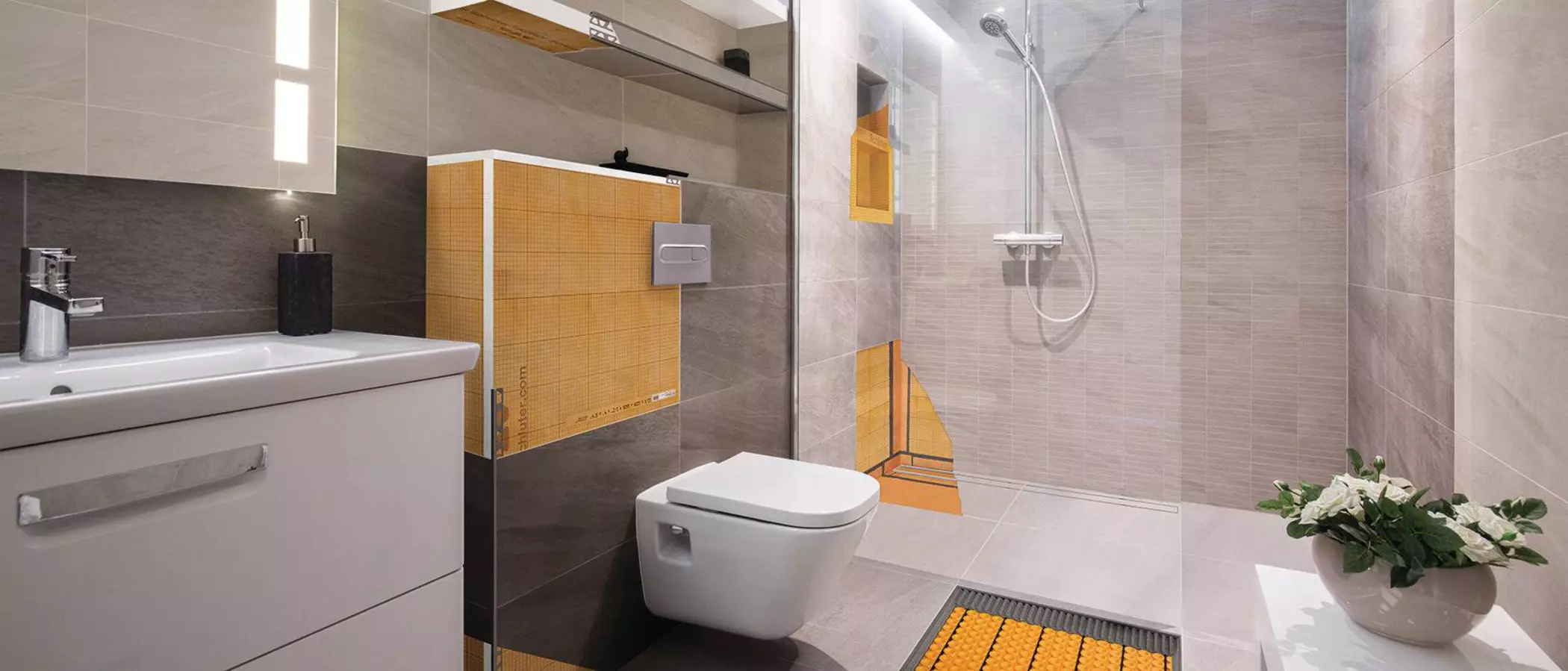 Modern, bright bathroom with partially visible Schl&uuml;ter-Systems products such as KERDI waterproofing and DITRA-HEAT underfloor heating under the tiled surfaces.