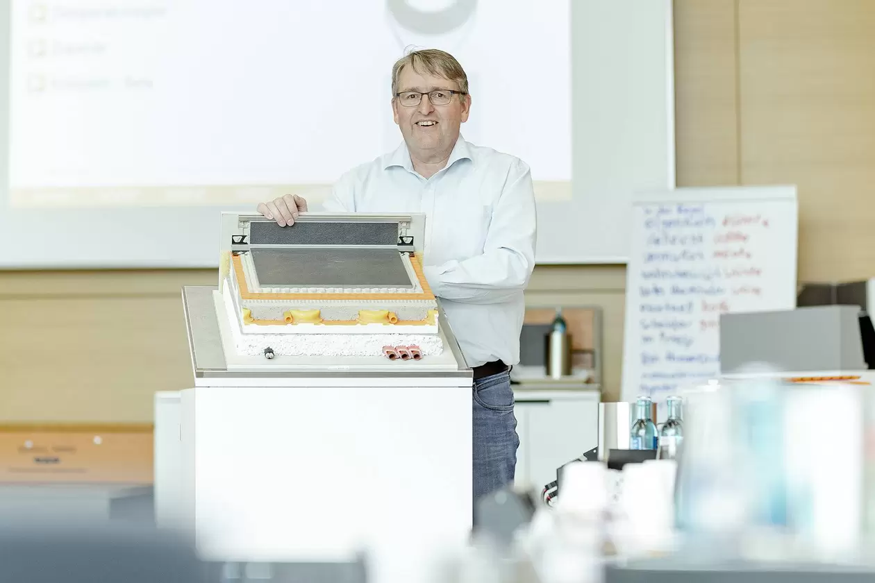 Seminarleiter steht vor einem Modell